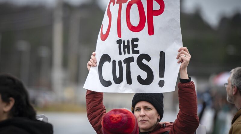 A person holds up a reading sign "Stop the Gaps" during an external protest.